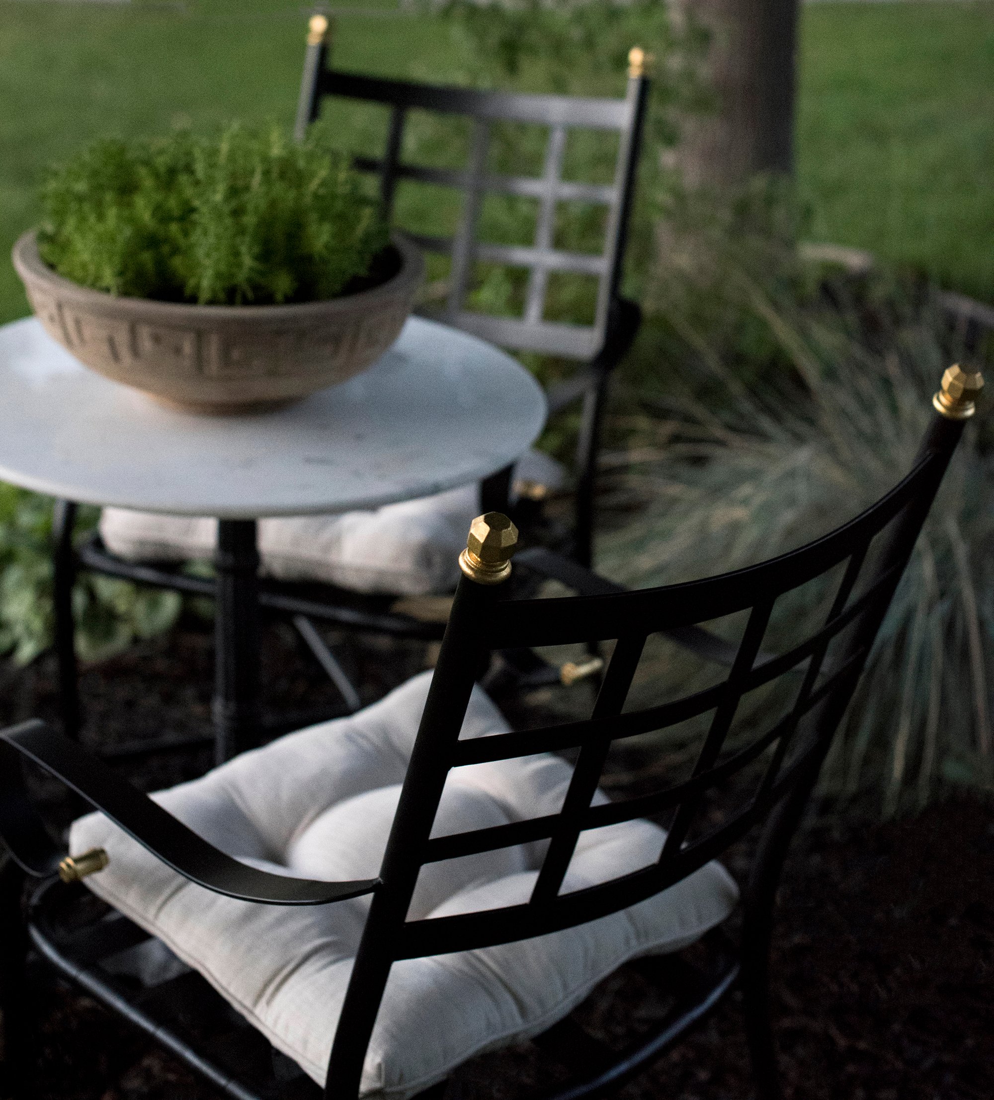 Iron patio chairs with gilded finials and french tufted cushions